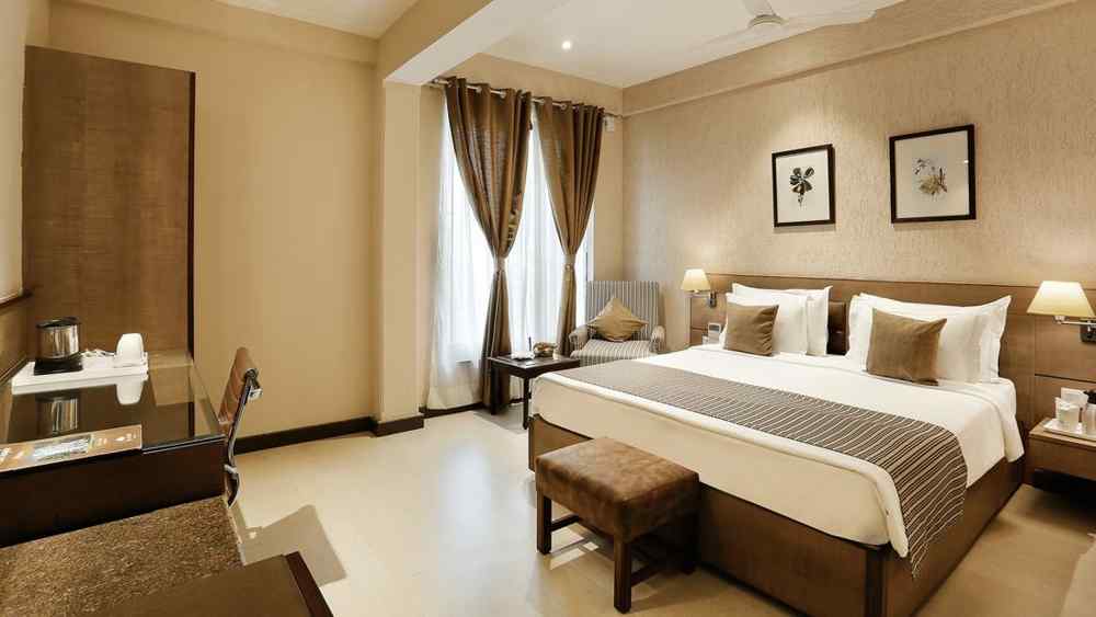 an image of suite at The Manor in Bareilly, featuring a plush bed and a stylish tea/coffee maker