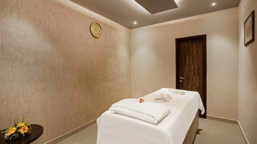  An image of a spa, with a bed in gentle light from the ceiling - The Manor, Bareilly