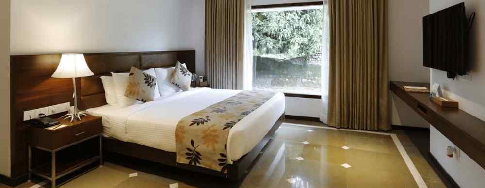 An image of a bedroom with double size bed, flat TV screen, and a bedside table with lamp - The Riverside Retreat, Corbett