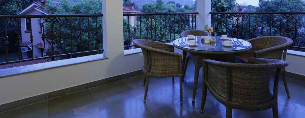 Sit-out area in the balcony with a circular table and 3 chairs - The Riverview Retreat, Corbett
