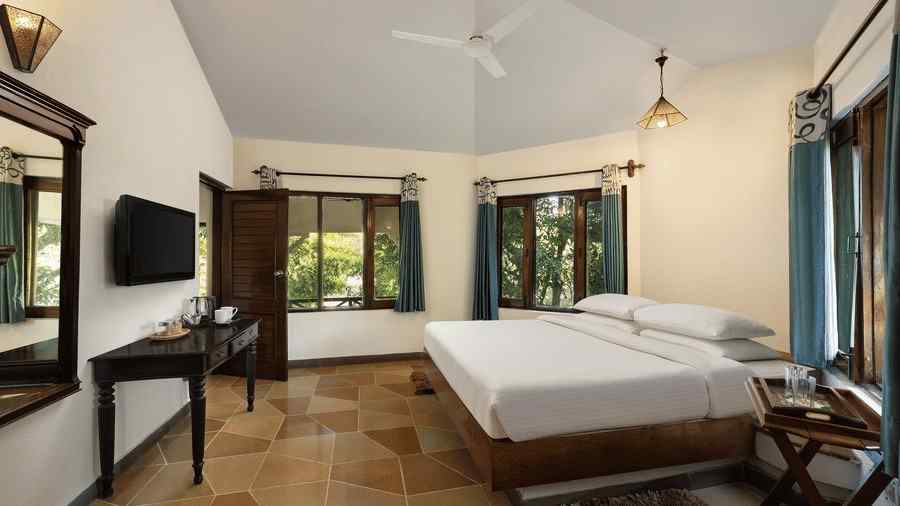 An image of a bedroom with double size bed, frames hanged on the wall, flat TV screen, work desk with chair, and a fan on the ceiling - The Riverview Retreat, Corbett