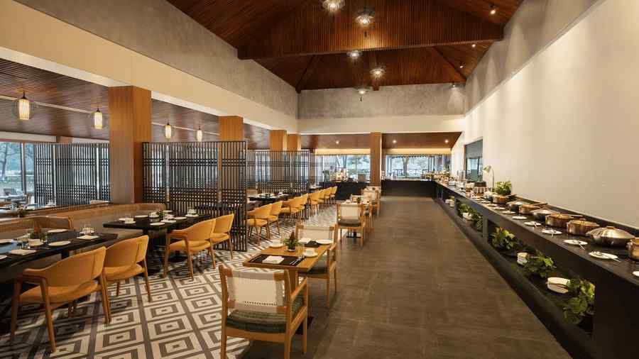 An image of a dining area with chairs and table set and a buffet counter at one side