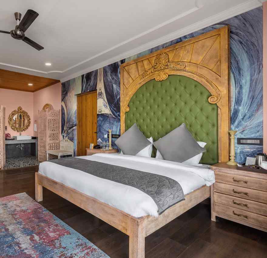 a bedroom with a large double bed and two sofas with a table - Atman, Dharamshala