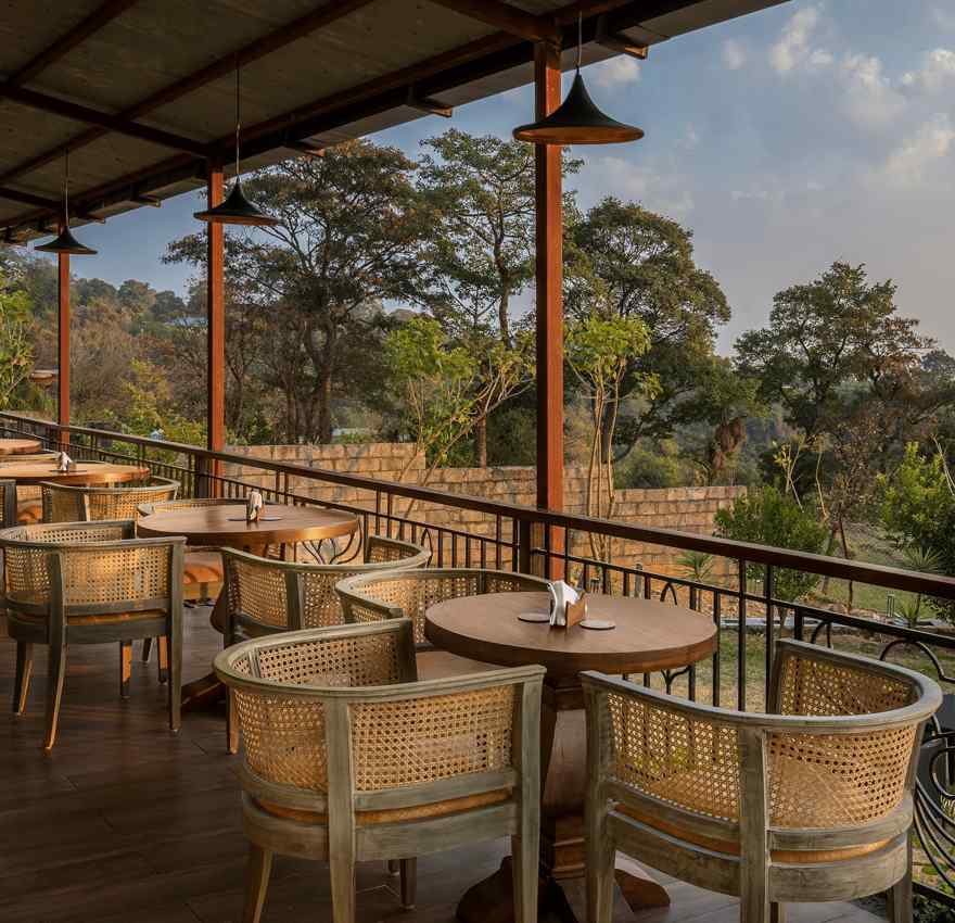 An image of Outdoor seating area with a view of trees and mountains at Atman, dharamshala.