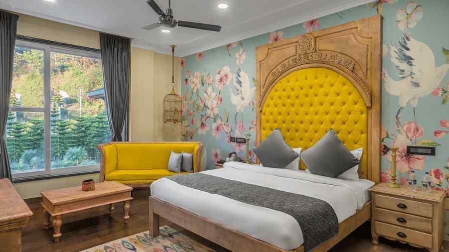 A Deluxe Room with a large bed with a headrest and a sofa beside it - Atman, Dharamshala