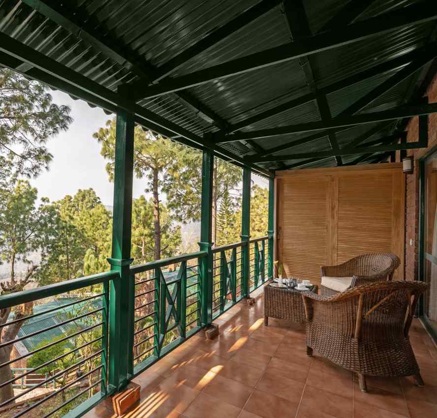 Premium Cottage sitting area with wooden chairs and beautiful greenery view - At baikunth Resort, Kasauli