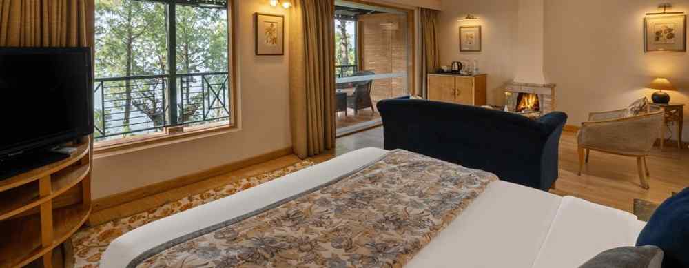 A premium cottage room featuring a cosy bed, open windows, and wall light fixtures that create a warm ambience -  Baikunth resort, kasauli 