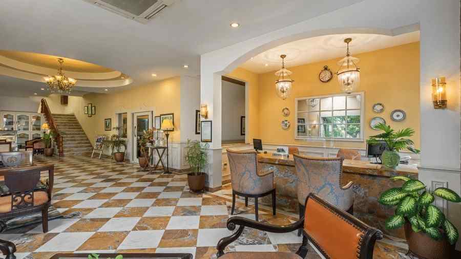 A wide view of the reception of the hotel with chairs and tables in clusters across the room - The Manor, Kashipur