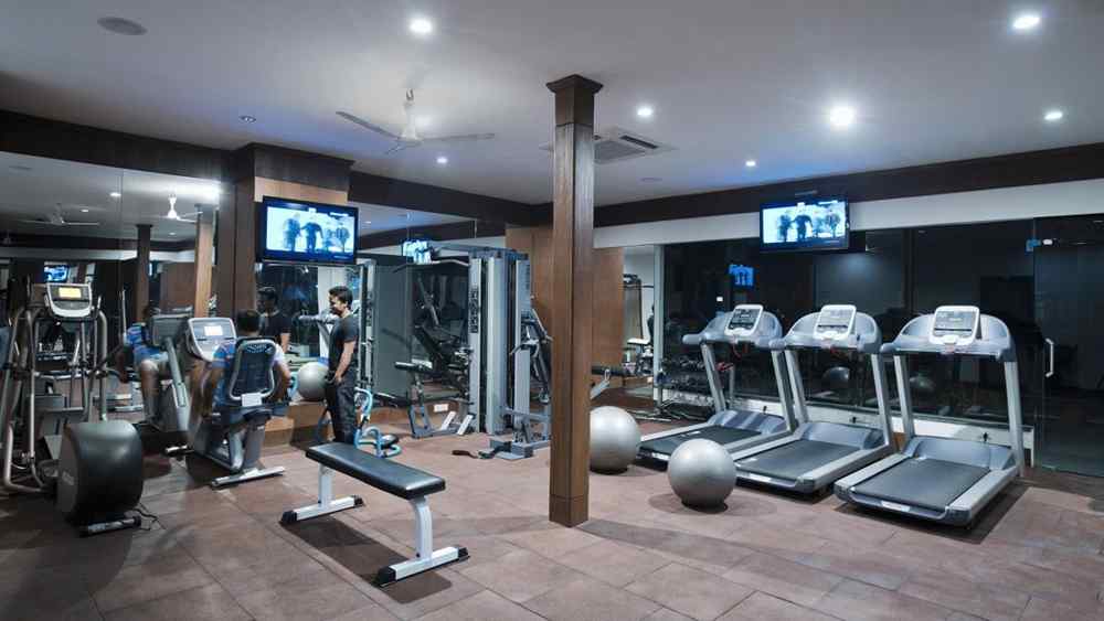 A gym space filled with various fitness equipment, including weights, machines, and cardio gear, arranged for easy access and use