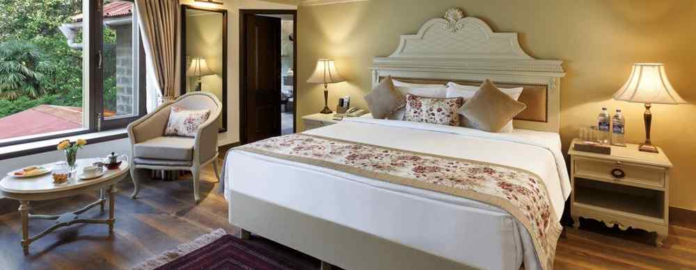 A cosy room with comforting decors, king size bed, wooden ceiling - The Naini Retreat