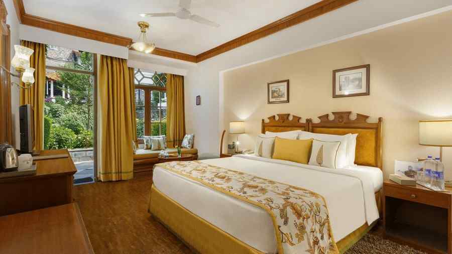 A full view of a garden facing room with a bed -the naini retreat, nainital.