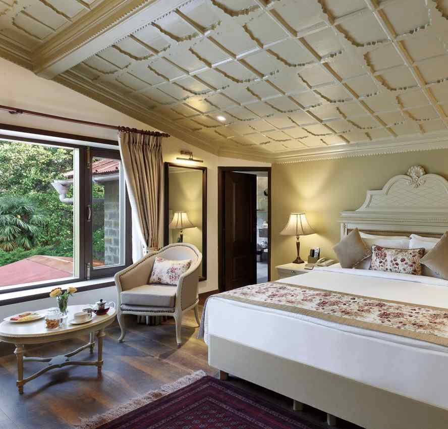 A cosy room with comforting decors, king size bed, wooden ceiling - The Naini Retreat