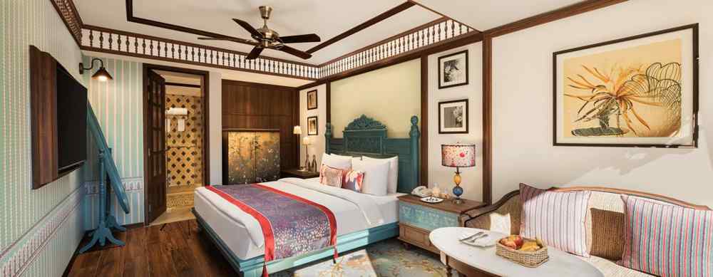Premium Garden Room at naini retreat, nainital, A cozy and inviting hotel room with a king-size bed, The room features a small sitting area with a sofa and a side table, as well as a large window overlooking a garden.