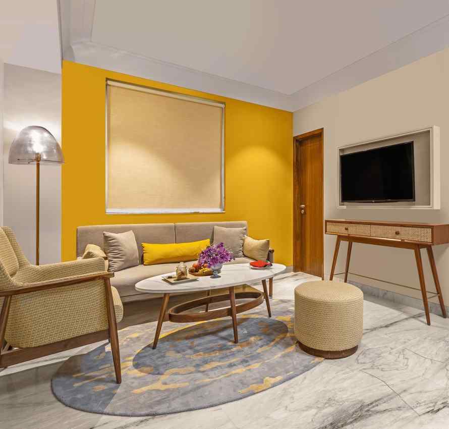 The room features a comfortable sofa with colourful pillows, a round coffee table, A floor lamp stands beside the sofa, providing ambient lighting.
