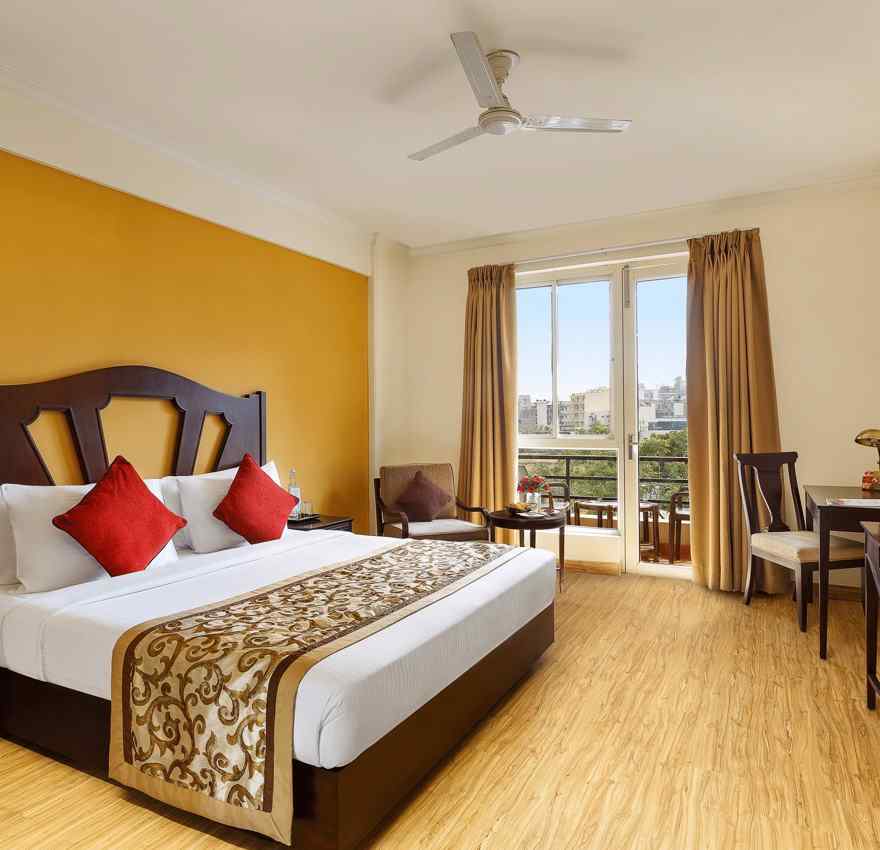 One bedrooom standard apartment with a large bed facing a television and a workdesk and ceiling fan - Aloha On The Ganges, Rishikesh